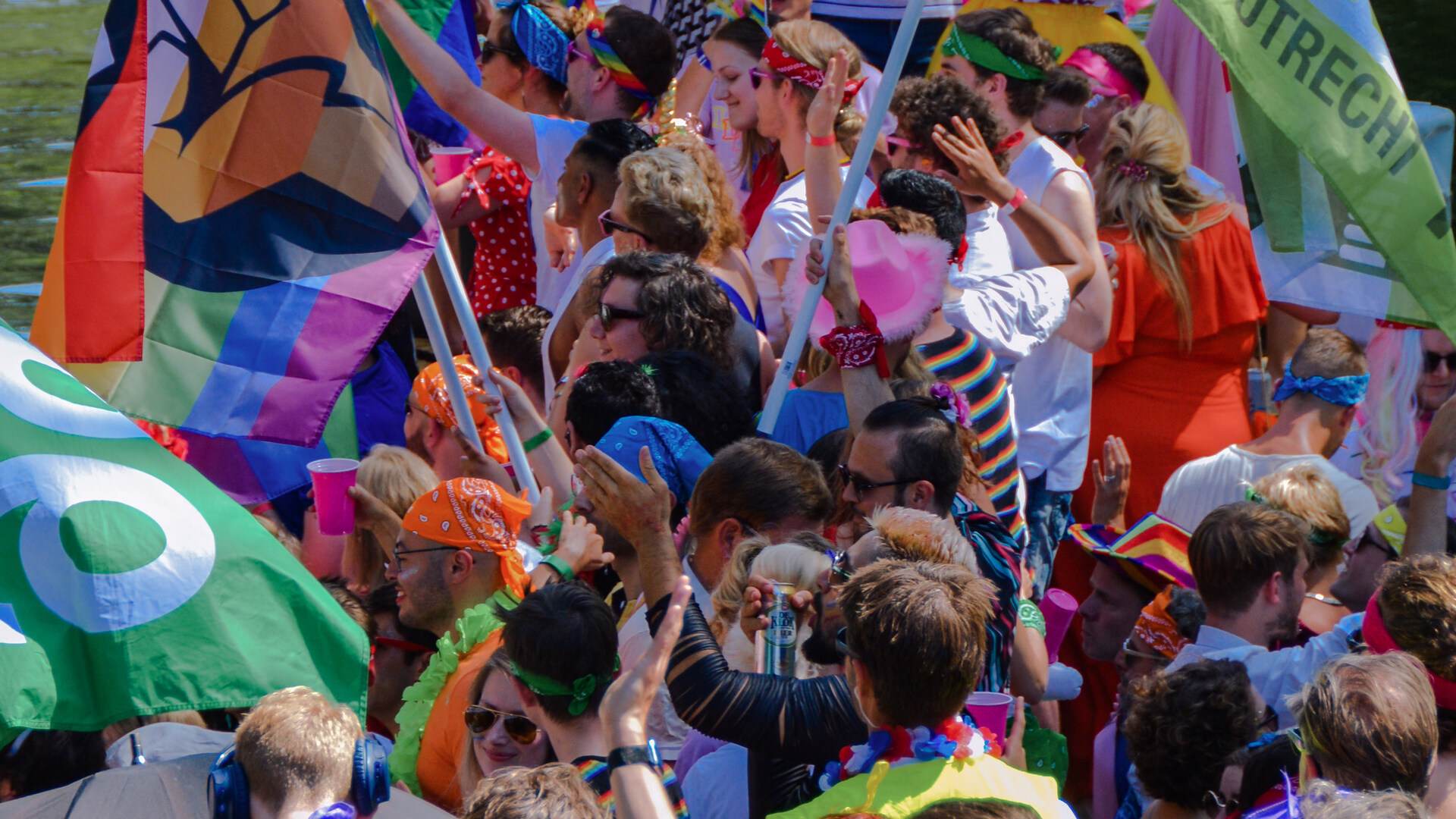 Canal Pride - Mensen met regenboogvlaggen op een boot